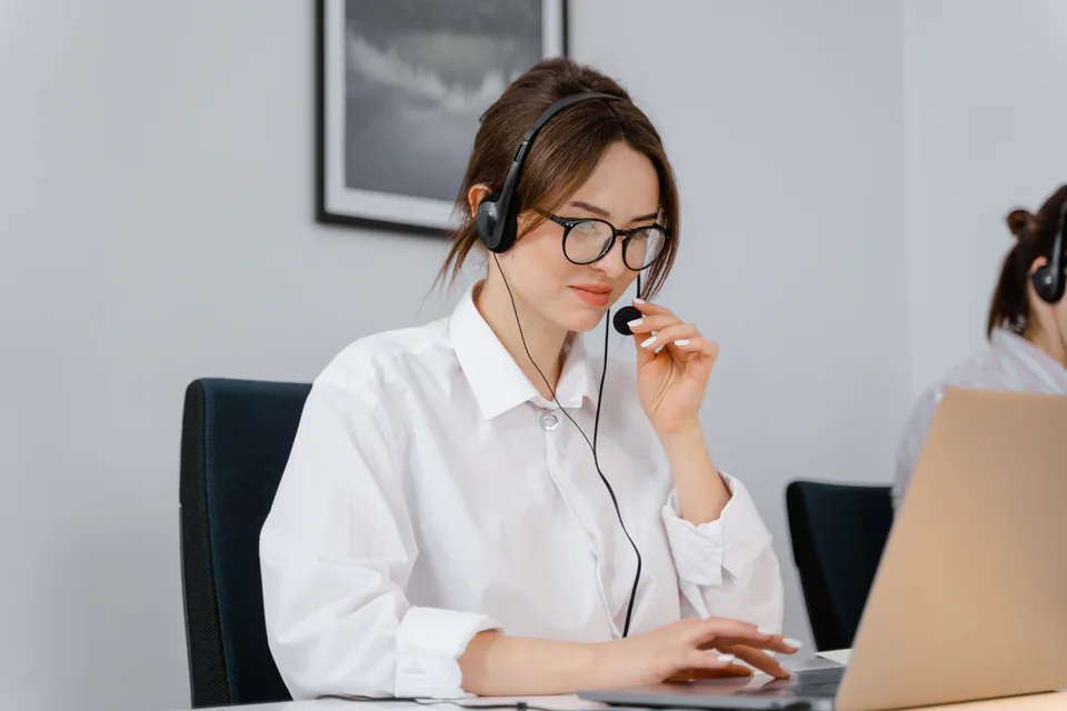 A support specialist with a headset working at a laptop