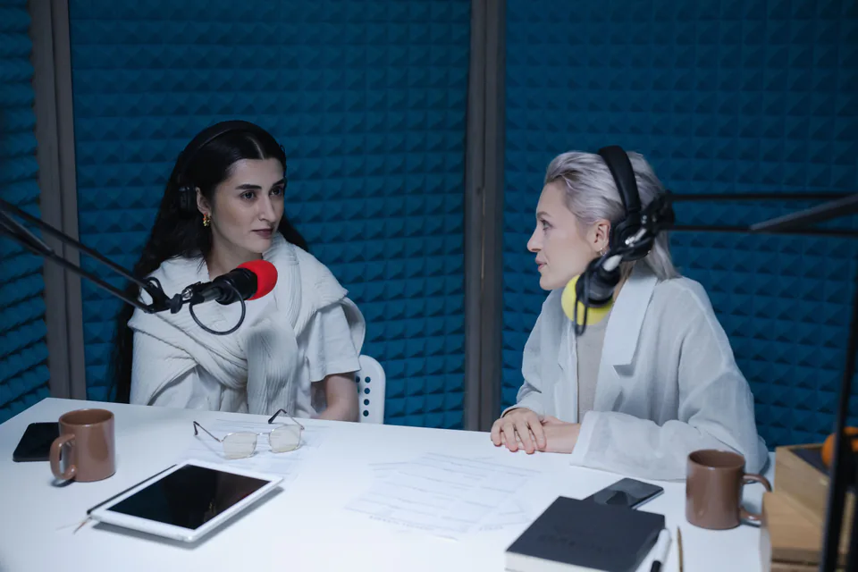 Two hosts recording a video podcast in an acoustically treated studio